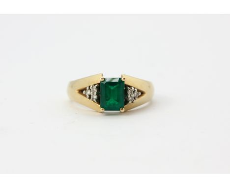 A 14ct yellow gold ring set with an emerald cut green stone and diamond set shoulders, (O.5).