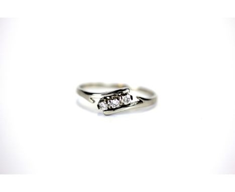 A white metal (tested high carat gold) diamond set crossover ring, (Q).