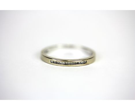 An 18ct white gold diamond set half eternity ring, (M.5).