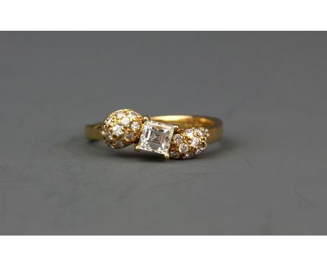 An 18ct yellow gold (stamped 18k) ring set with an approx. 0.50ct baguette cut diamond and brilliant cut diamond set shoulder