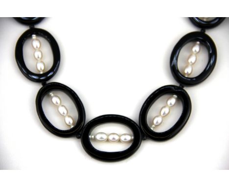 An unusual Art Deco style necklace of polished onyx discs and white freshwater pearls. The disc size 3.5cm, necklace L. 44cm.