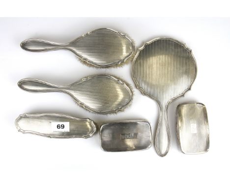 A four piece hallmarked silver dressing table set with engine turned decoration together with a pair of hallmarked silver bac