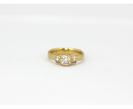 An 18ct yellow gold (stamped 750) ring set with an 0.48ct brilliant cut diamond and baguette cut diamond set shoulders, (M).