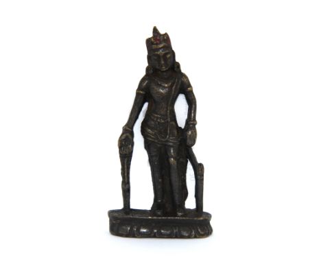 A Tibetan bronze figure of a standing Deity with remnants of colour to the crown, H. 7cm.