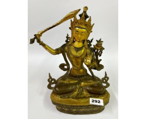 A Tibetan gilt bronze temple style figure of a seated Tara with hand painted facial features, H. 30cm.