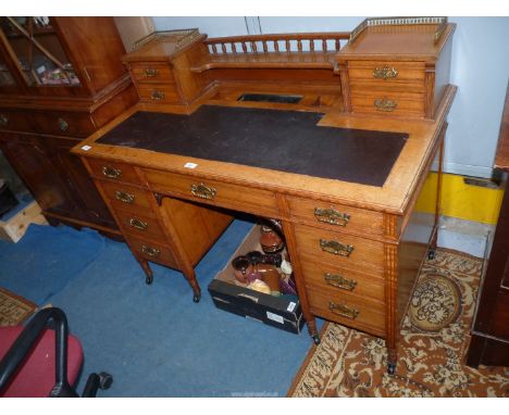 An attractive probably Edwardian light Oak Kneehole Desk with a central frieze drawer flanked to either side by four short dr