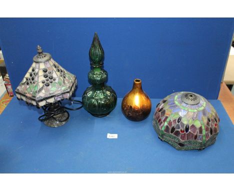 Two Tiffany style lamp shades (one shade a/f), a small table lamp, a large green glass stoppered bottle, etc.