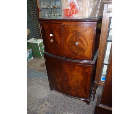 A contemporary bow fronted Mahogany cocktail/drinks Cabinet, the upper portion with a mid height glass shelf, the base with a