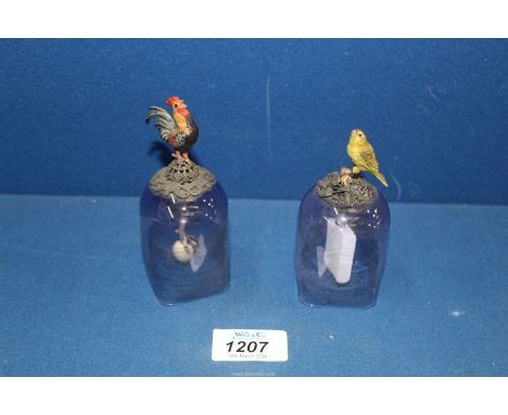 A pair of unusual and collectible glass bells, c. 1900, each surmounted by a cold painted bird and with ornate stone clappers