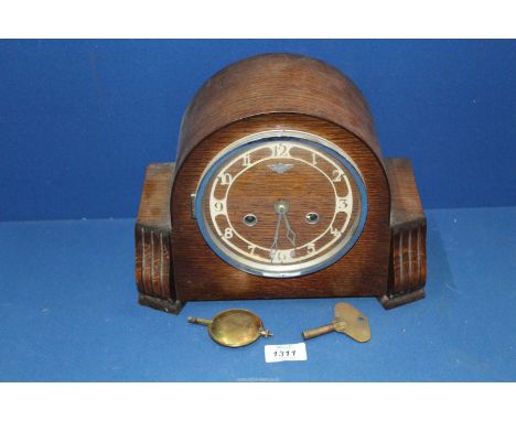 A Bentima Mantle clock with Arabic numerals, with key and pendulum, 11 1/2" wide x 9" high.