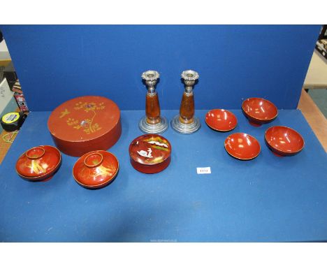 A quantity of 1950's lacquered Japanese trinket boxes, four lacquered sake or rice bowls, plus a pair of wood and metal candl