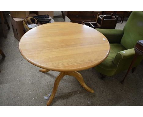 An Ercol light elm circular dining table raised on four footed base, top 100cm diameter