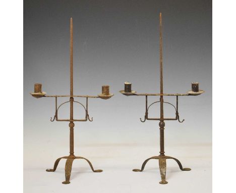 Pair of early 20th century wrought iron candle stands, the adjustable single branch supporting two cylindrical sconces and dr