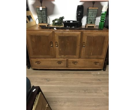 1970s BLOND ERCOL SIDEBOARD with three panelled cupboards enclosing shelving, height 78cms width 129cms