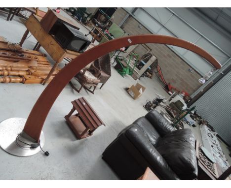 A vintage teak arched standard lamp