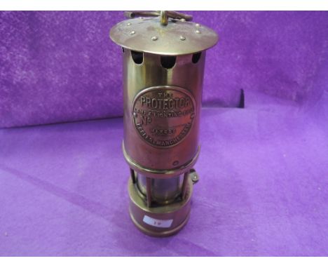 A vintage brass cast miners lamp 'The Protector' of Eccles Manchester 