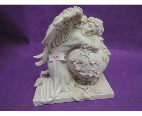 A vintage stone effect model of angel on sphere 