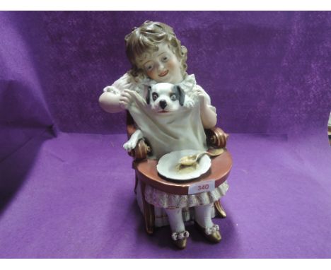 A vintage ceramic figure of large form, child feeding puppy dog,