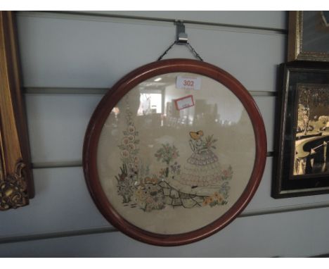 A vintage circular form needle work with flower garden and maiden imagery 