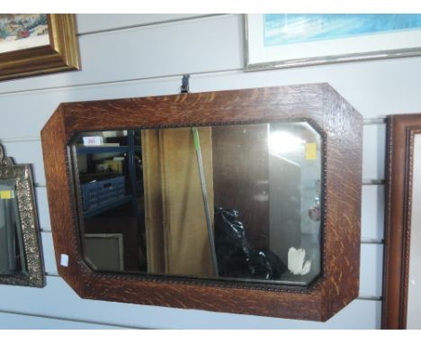 A vintage hallway mirror with carved oak frame