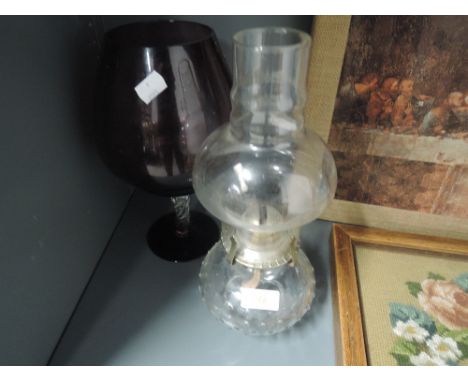 A vintage purple glass vase with twist stem and oil burning lamp