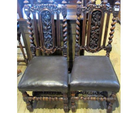 A pair of 19th century oak dining chairs, each having leaf and berry carved rail and splat within barley twist stiles, over-s