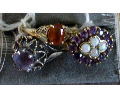 An open work amethyst and opal cluster ring, together with a citrine ring and a single stone amethyst ring in silver mount.