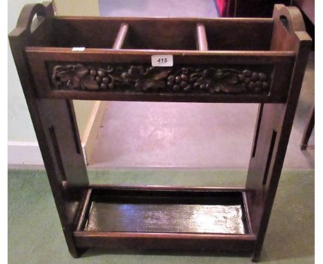 An early 20th century oak three section stick stand, carved in shallow relief with fruiting vines.