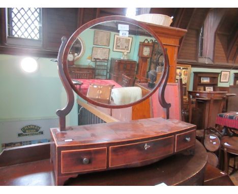 A 19th century mahogany toilet mirror, the oval plate within shaped horns on a bow fronted base with three fitted drawers, st