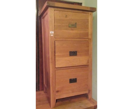 A 20th century light oak three drawer filing cabinet.