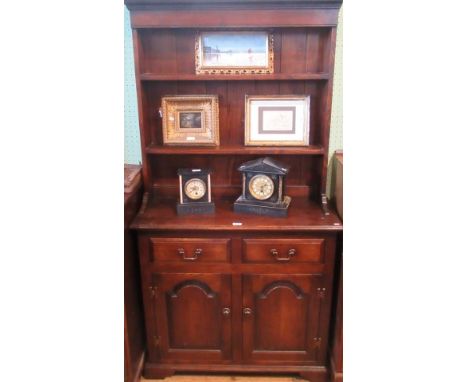 A reproduction oak tall dresser, the rack with two open shelves over two frieze drawers and a pair of arch fielded panelled d