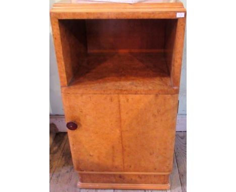 A bur walnut veneered bedside cupboard, with open shelf and door on plinth.