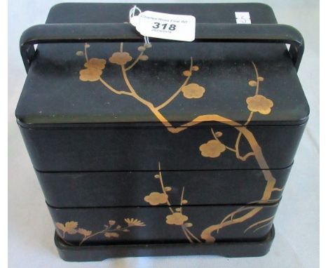 An early 20th century Japanese black lacquer and gilt chinoiserie decorated jewellery box in three sections.