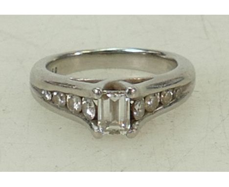 Platinum diamond ring: Ring set with a baguette diamond with smaller diamonds set in the shank, size J, 7.9 grams.