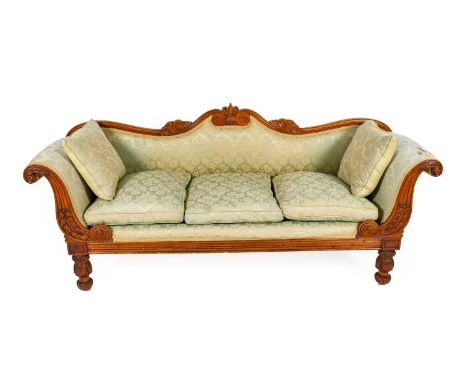 A George IV Carved Mahogany Three-Seater Sofa, 2nd quarter 19th century, recovered in green floral fabric, the scrolled and c