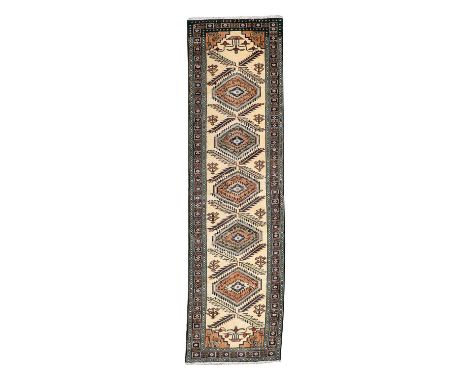 North-West Persian Runner circa 1960The ivory field with a column of medallions and serrated leaves enclosed by narrow border