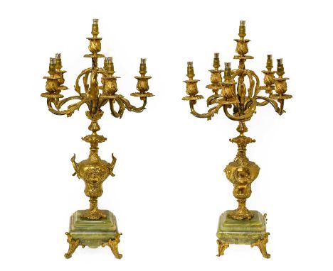A Pair of Gilt Metal and Onyx Six-Light Candelabra, late 19th century, with urn shape scones and leaf-sheathed scroll branche