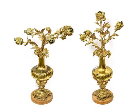 A Pair of Gilt Metal Four-Light Candelabra, in Louis XV style, as flowers issuing from wrythen fluted and leaf cast baluster 