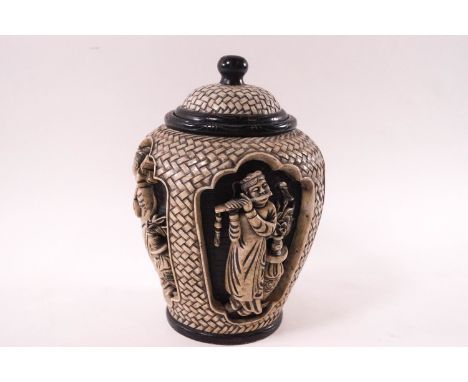 A Chinese marble jar and cover, the body carved in heavy relief of four figures, some playing instruments against a black gro
