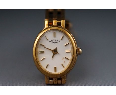 A yellow metal ladies wristwatch. Oval ceramic dial with baton markings, signed Rotary. Straight gate link bracelet with fold