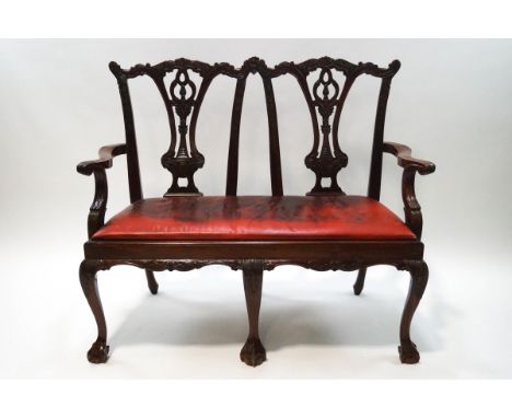 A Chippendale style carved mahogany double back settee, red leatherette upholstery, 99cm high x 119cm wide x 52cm deep