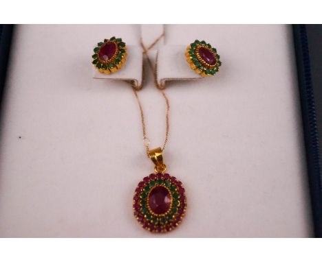 A 22ct yellow gold oval cluster pendant set with very low commecial grade rubies and emeralds. Together with a matching pair 