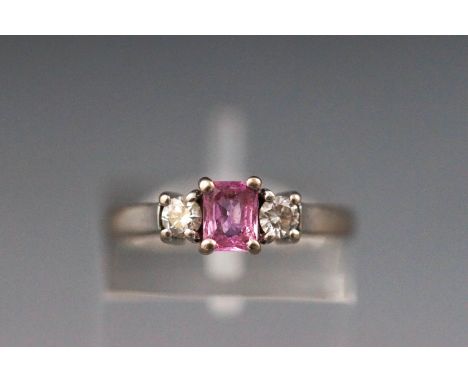 A white metal three stone ring set with pink sapphire and diamonds. Hallmarked 18ct gold, Sheffield, 2005. Size: K 3.3 grams