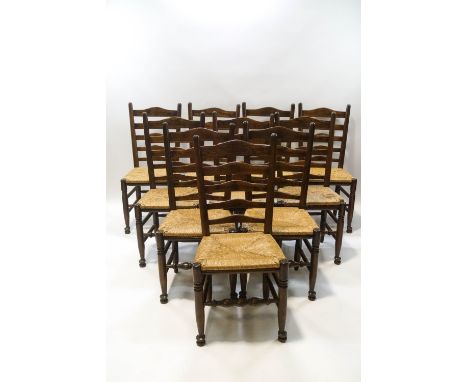 A set of ten 18th century style oak ladder back chairs with rush seats