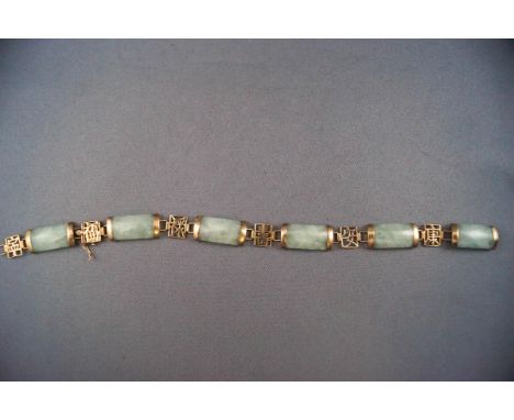 A jade linked bracelet interspaced with yellow metal pierced links of Chinese symbols. Push in clasp with figure of eight saf