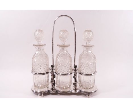 A late Victorian silver plated decanter stand by Naylor Clark & Co 1875, holding three cut glass bottles and stopper