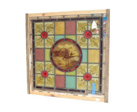 An Arts &amp; Crafts Stained Glass Panel, the central roundel painted with a swallow and butterfly, surrounded by painted and