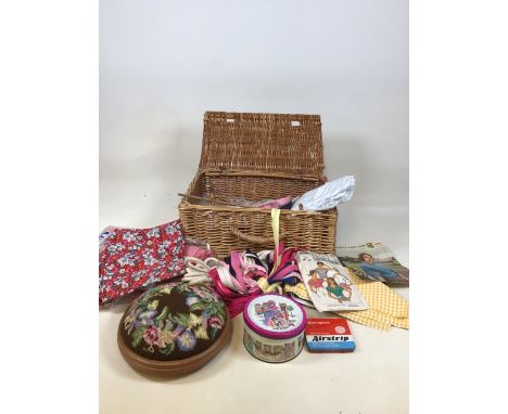 A wicker hamper with a quantity of sewing items 