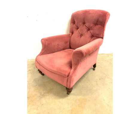 An upholstered button back Victorian arm chair with turned front legs and large ceramic castors. Seat height H:35cm