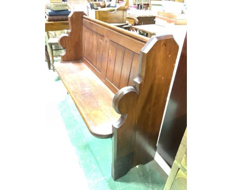 A small church pine pew with book rest to back and umbrella and stick rest to side.W:126cm x D:47cm x H:93cm